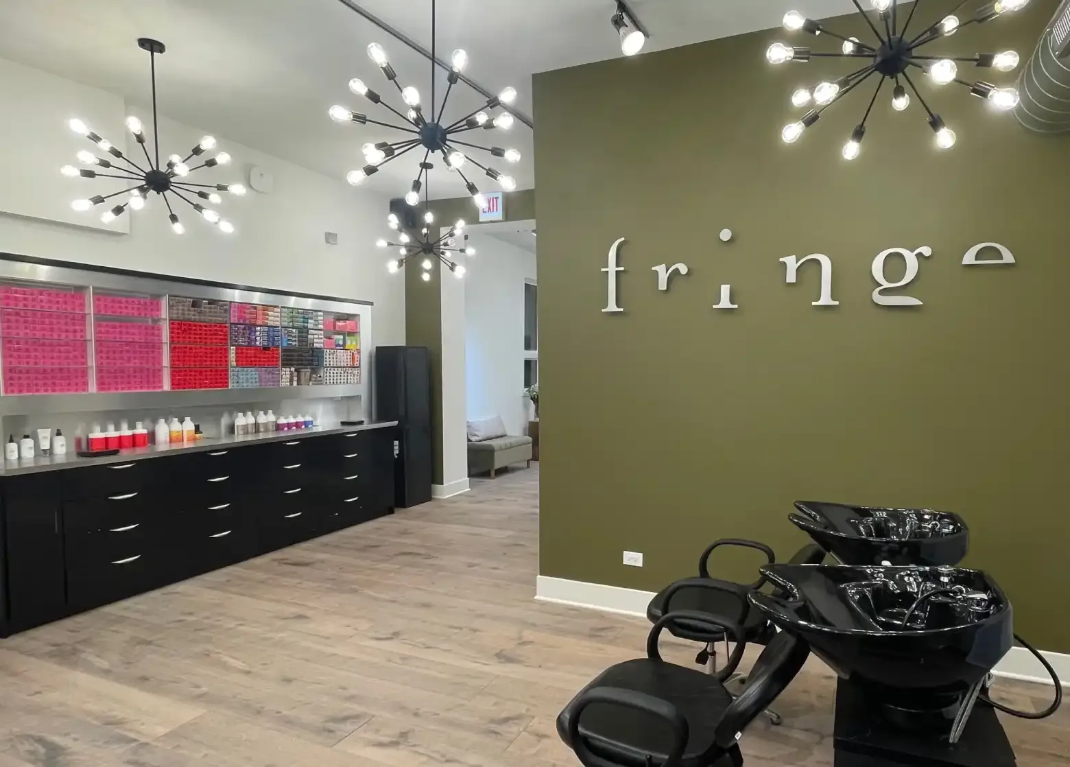 Fringe salon interior with the Fringe logo wall and shampoo stations