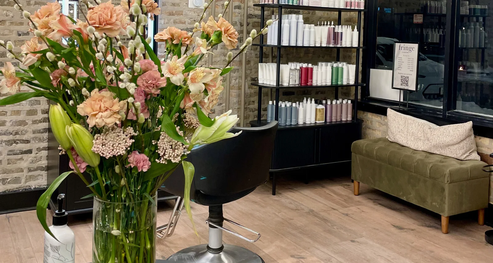 Fringe salon styling chair, fresh flowers and product shelves